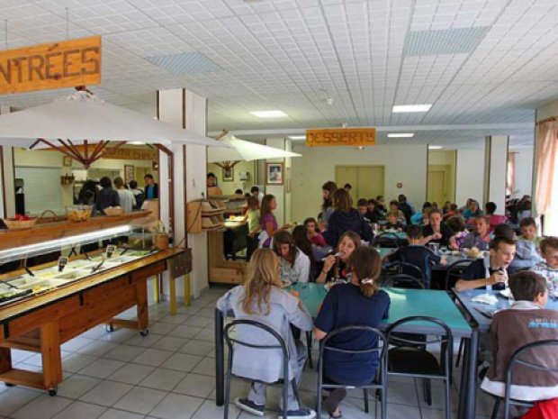 Enfants de la colonie de vacances mangent dans le réfectoire du centre de vacances à la montagne