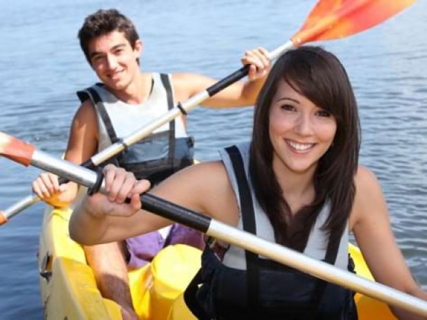 Jeunes de la colonie de vacances itinérante en Suède en train de faire du Canoé