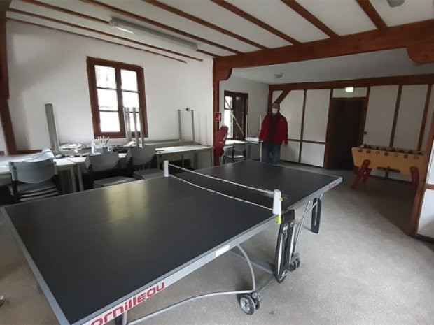 Vue sur la salle d'activité rénovée avec une table de ping pong au centre de vacances La Chaudane